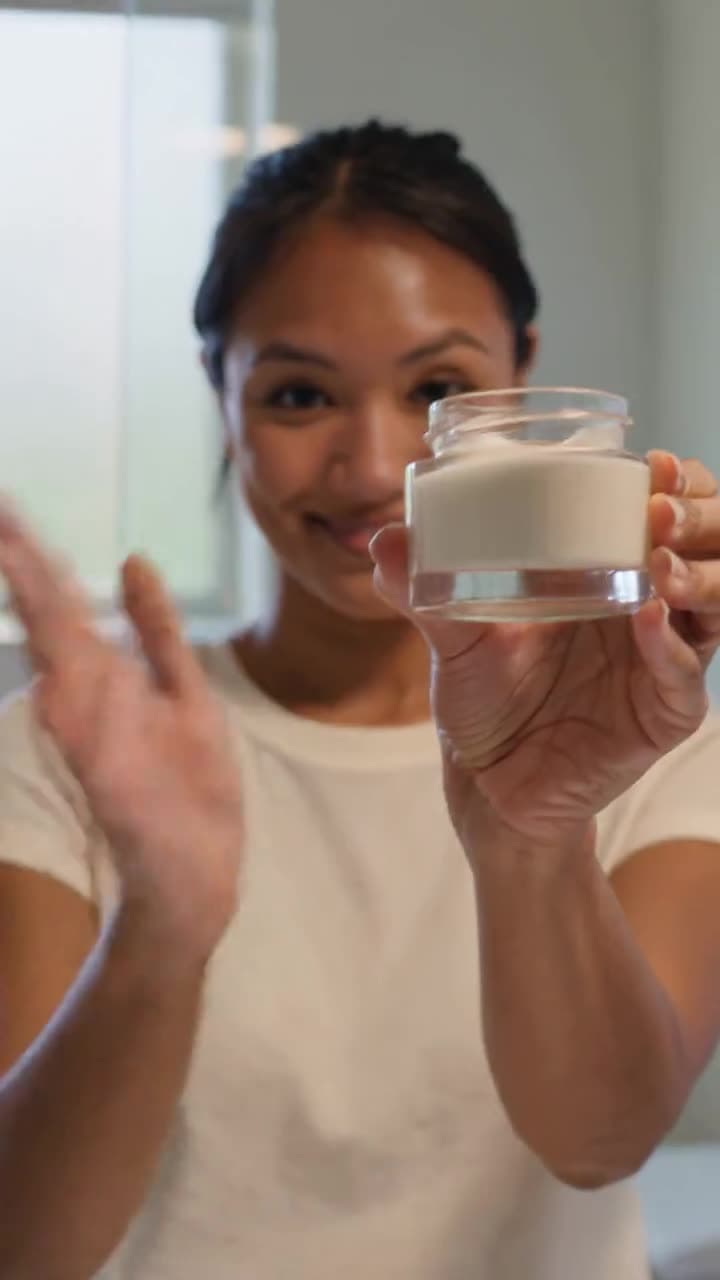 A creator holding a skincare jar up to camera in a bright bathroom — a Kling 3.0 generation